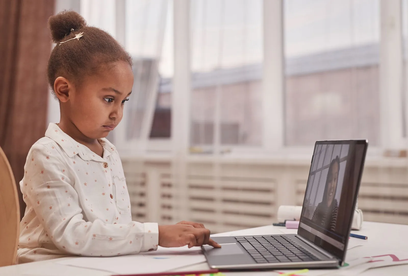 Niña frente a un computador portátil durante una clase online